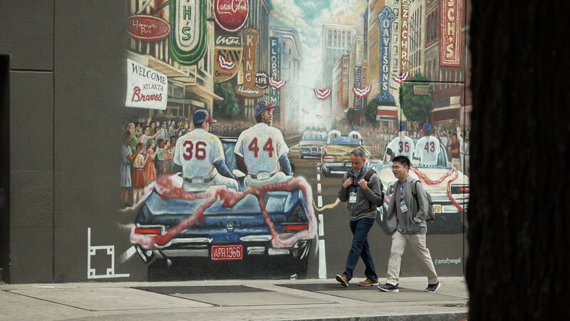 Two men walk past a mural honoring the 1966 Atlanta Braves in Downtown Atlanta.