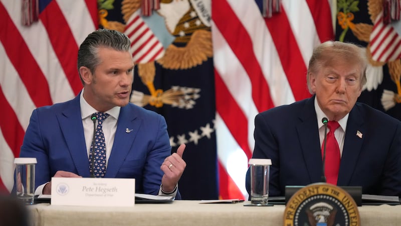 President Donald Trump listens as Defense Secretary Pete Hegseth speaks at a roundtable event...
