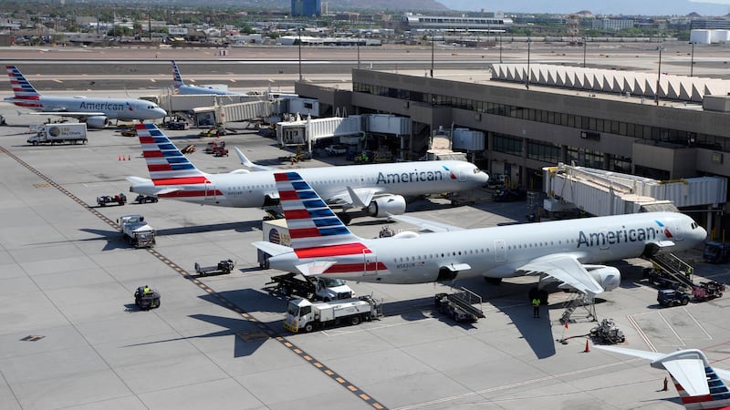 FILE - American Airlines planes wait at gates at Phoenix Sky Harbor International Airport...