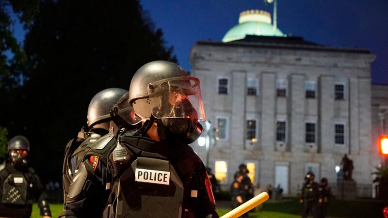 Police in riot gear protect the old state capitol building in Raleigh, N.C., on Sunday, May...