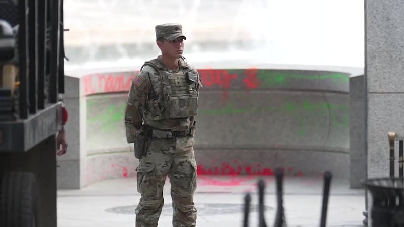 A soldier stands in front of the World War II memorial in Washington, D.C., following a case...